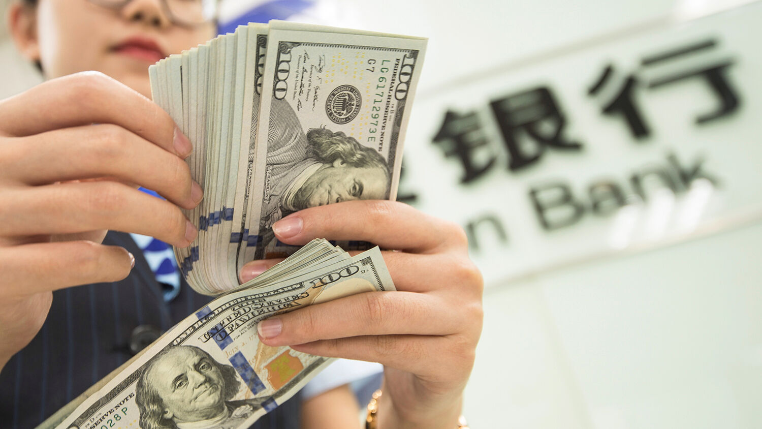 Image result for A Chinese bank employee counts U.S. dollar bills at a bank counter on Aug. 6, 2019. STR/AFP VIA GETTY IMAGE